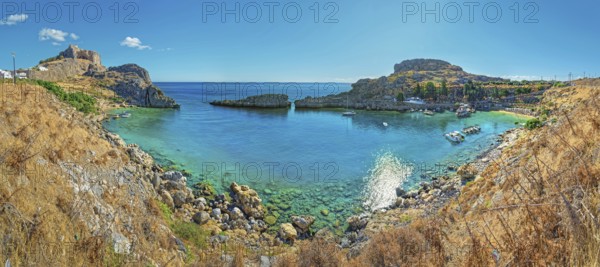 Clear panoramic view of Paulus Bay of Lindos with turquoise water and boats, Acropolis, Lindos,