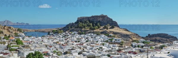 Panoramic view over the coastal landscape of Lindos with Acropolis and hills in the background,