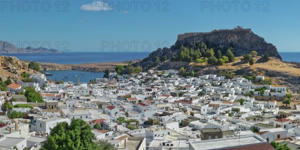 The picturesque town of Lindos with acropolis with white buildings near the coast, overlooked from