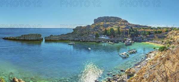 Panoramic view of the calm Paulus Bay of Lindos with turquoise-coloured water, surrounded by