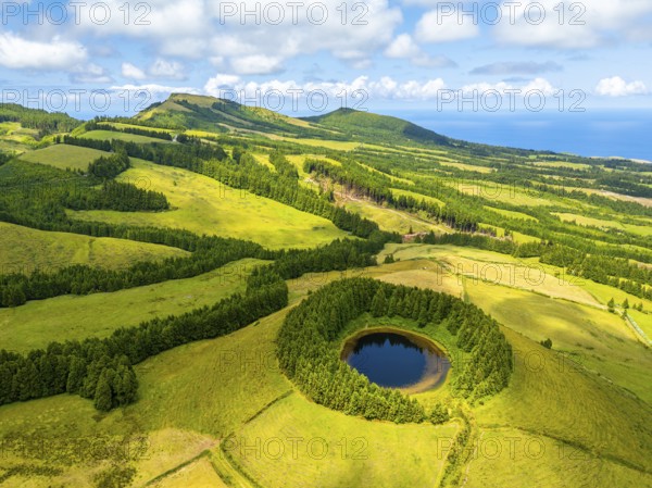 Lake Pau Pique and Lush Green Hills with Pastureland and Trees. Shadows of Clouds. Atlantic Ocean.