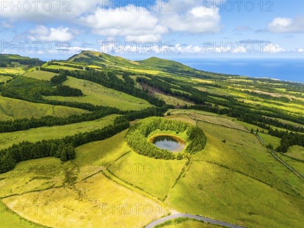 Pond Pau Pique and Lush Green Hills with Pastureland and Trees. Shadows of Clouds. Atlantic Ocean.