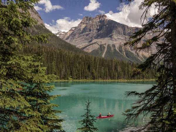 Canoe with explorers on Emerald Lake surrounded by the Canadian Rocky Mountains within Yoho