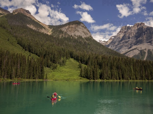 A group canoeing on Emerald Lake with the dramatic Canadian Rocky Mountains as a scenic backdrop