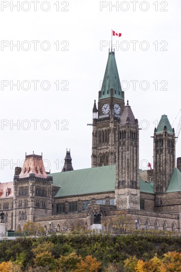 The Canadian parliament building with a prominent clock tower and Canadian flag in Ottawa, Ontario,