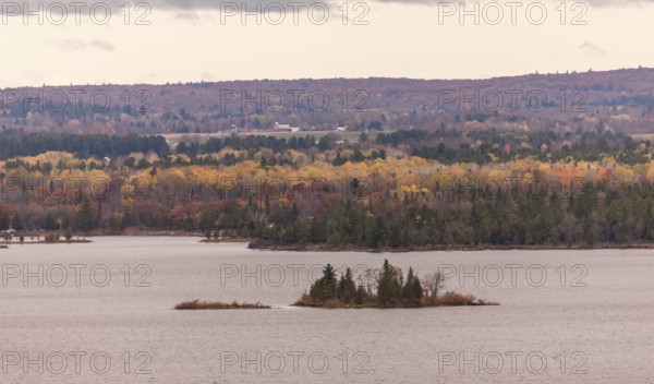 The Ottawa River with small islets surrounded by colorful autumn trees and hills in Ottawa,