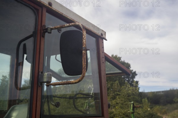 Borken, NRW, Germany, Rusty cabin and side mirror of an old agricultural tractor showing rural
