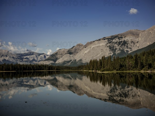 Scenic view of mountains of the Canadian Rocky Mountains mirrored in a still lake on a clear day