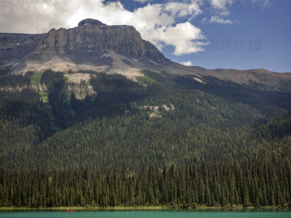 Serene landscape featuring a forest-lined Emerald Lake with the Canadian Rocky Mountains in the