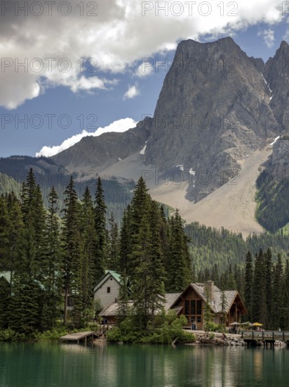 Cabin by a tranquil Emerald Lake with towering mountains of the Canadian Rocky Mountains and a