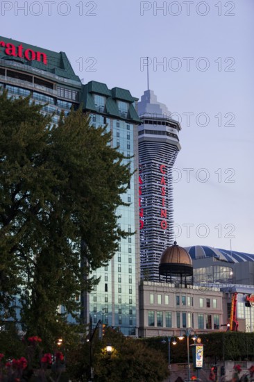 Tall hotel and casino buildings with bright signage against an evening sky in Niagara Falls,