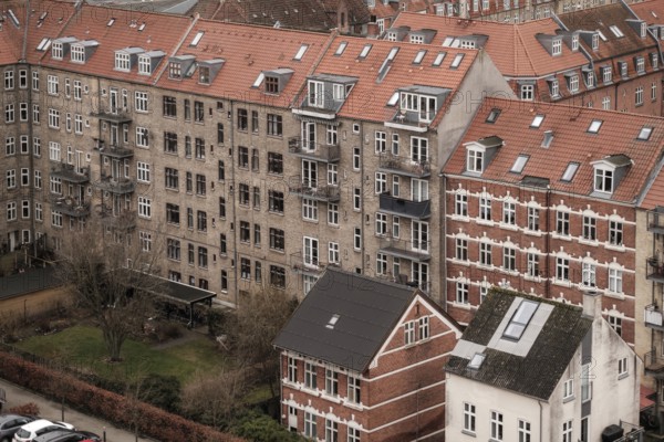 Dense urban scene with red tile roofed residential buildings under an overcast sky in Aarhus,