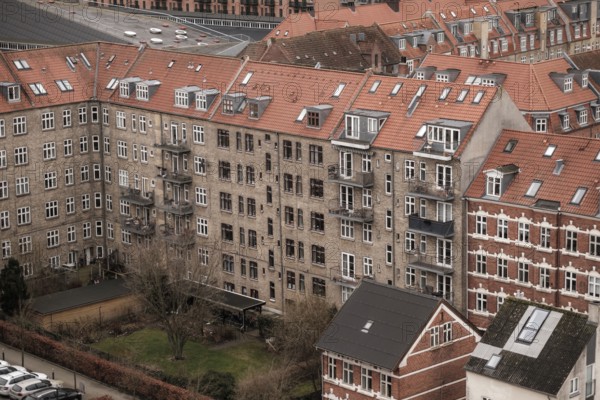 View of apartment buildings with red tile rooftops under a cloudy sky in Aarhus, Denmark, Northern