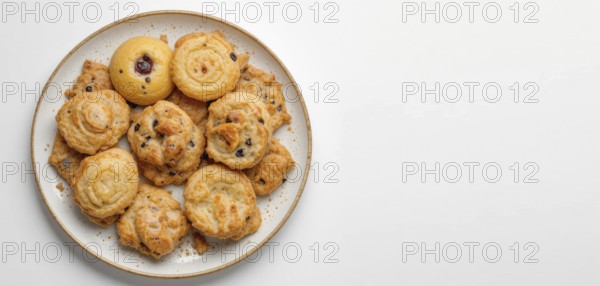 A top-down shot showcases a variety of golden-brown cookies arranged on a speckled plate against a