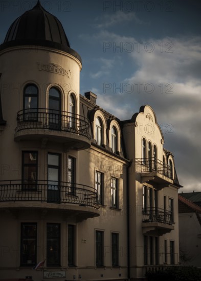 Sunlit historic European building with dramatic shadows against a cloudy sky in Helsingborg,
