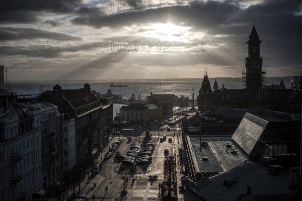 A dramatic city view with a silhouette against a sunset over the Oresund Strait, between Sweden and