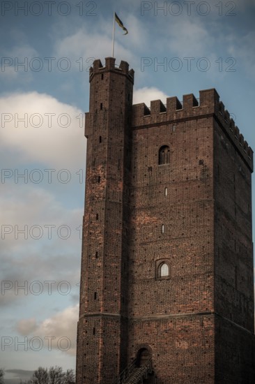 The Karnan medieval tower, built in the early 14th century, with a flag set against a blue sky with