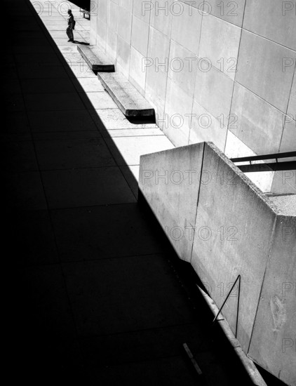 Geometric black and white scene with sharp shadows and a solitary person against a wall in Toronto,