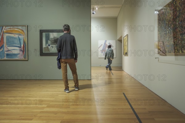 Jan 13, 2024 - Lisbon, Portugal: two visitors explore abstract artworks displayed on walls of
