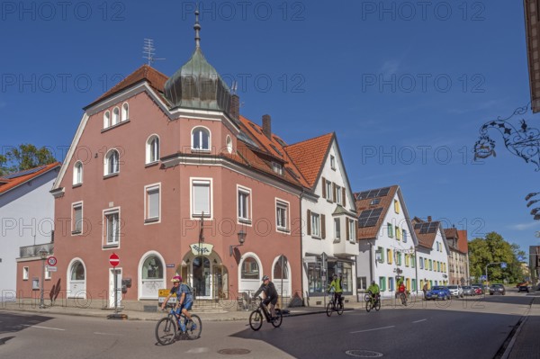 Blue sky, street with cyclists, pointed gable houses and ZAPPA BAR in Kisslegg, Allgäu,