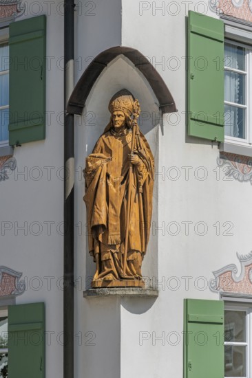 Blue sky, house with green shutters and bishop figure in corner niche, Kisslegg, Allgäu,