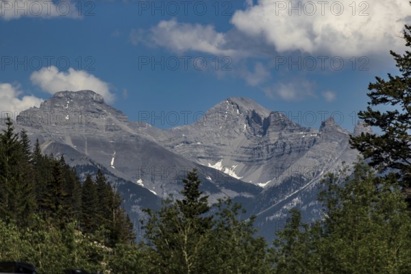 Rocky mountain peaks under a blue sky with clouds inside Yoho National Park in British Columbia,
