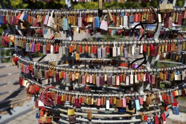Close-up of numerous colourful padlocks attached to metal rings, Nuremberg, Middle Franconia,