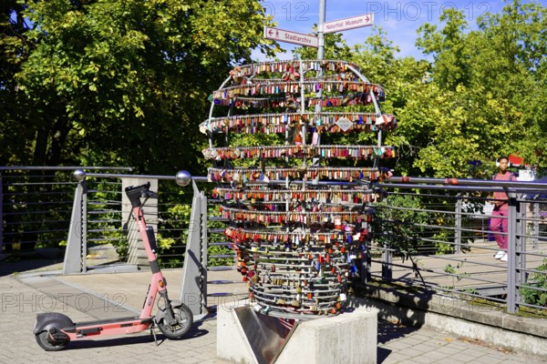 Electric scooter next to a large heart made of padlocks outdoors, Nuremberg, Middle Franconia,