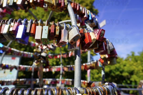 Several colourful padlocks attached to a metal frame outdoors, Nuremberg, Middle Franconia,