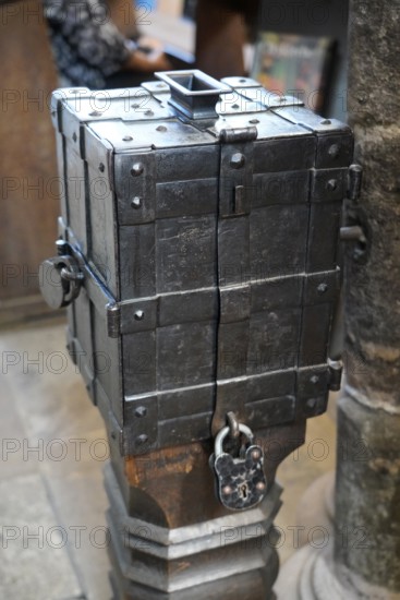 An antique metal box with a lock on a wooden floor, rustic and historic in appearance, St. Lawrence