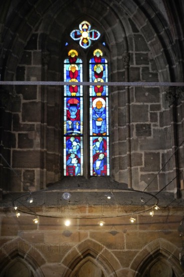 Stained glass window with artistic depictions in a Gothic church, Church of St. Lawrence,