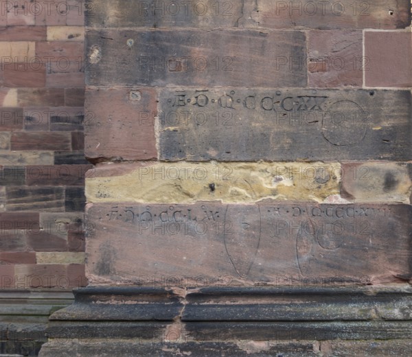 Historic engravings on a stone wall at the Freiburg Minster in Freiburg im Breisgau, a city in