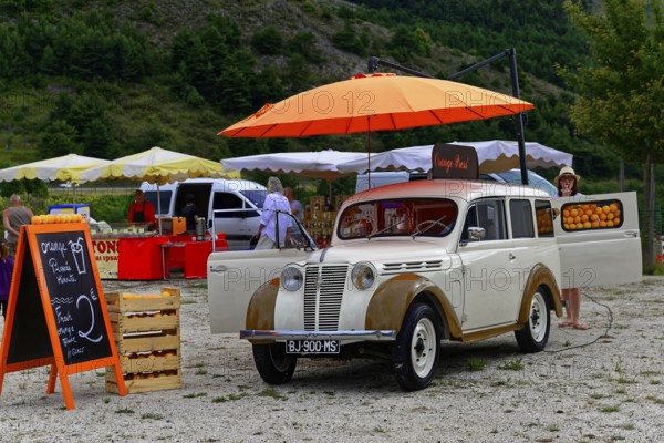 A white vintage car at a market, decorated with oranges, Provence, Département