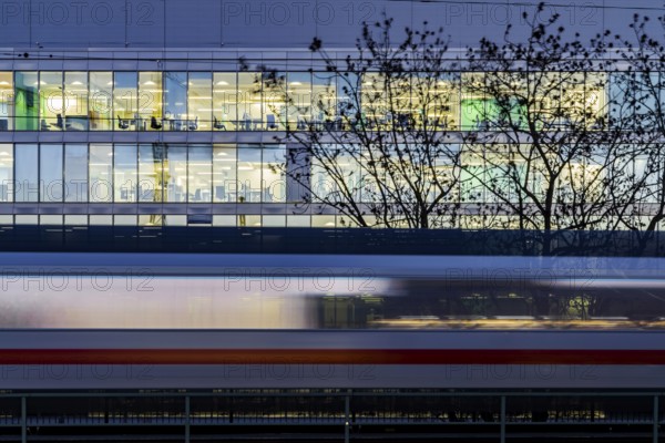 Office building at night. In front of it a passing ICE train of Deutsche Bahn AG. Stuttgart,