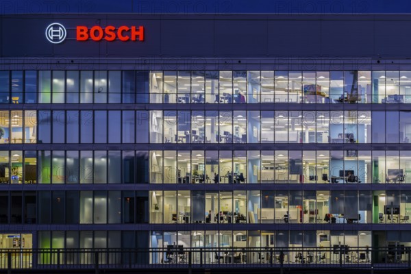 Modern office building of Bosch GmbH in Feuerbach at night with illuminated logo of the automotive