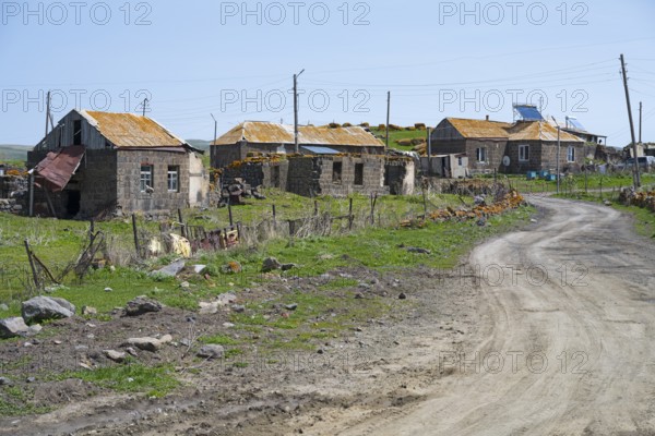 Quiet village with old buildings along a dirt road in a green landscape, Berdashen, Lake Arpi,