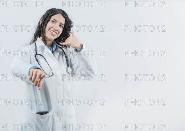 Beautiful female doctor gesturing call isolated. Woman doctor making call gesture and pointing at