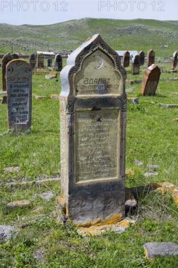 Historic gravestones on a grassy cemetery with hills in the background, old cemetery, Aghvorik,