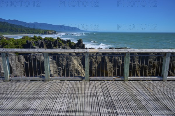 View from a platform with wooden railings of the rugged coastal rocks and the sea, Pancake Rocks,