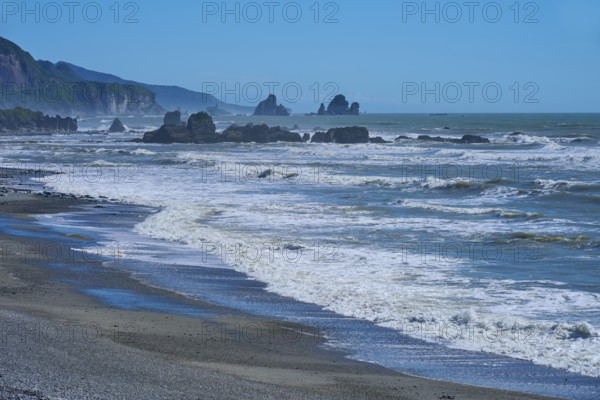 Stormy waves crash against an unspoilt coastline with striking rock formations, West Coast, South