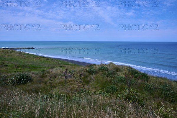 White sandy beach with grassy coastline and gentle waves under a cloudy sky, Mana Bay, Riverview