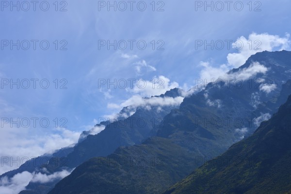 Mountain peak in the foreground with white clouds in the sky, Drift Bay, Lake Wakatipu,