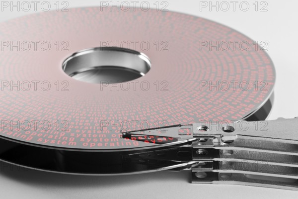 Detail shot of a separated hard disk platter with actuator arm in light grey backAllegory theme