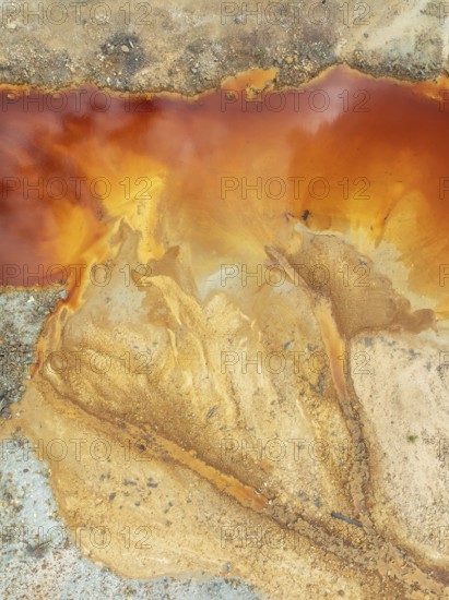 Deep orange-red hues in the water of a pool in the mineral-rich area of the Rio Tinto mines. The