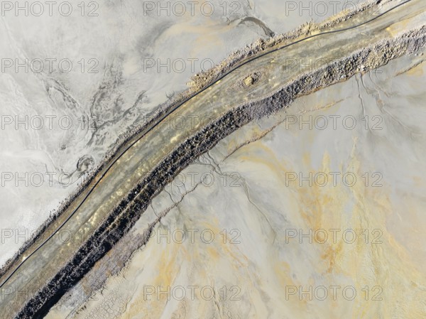 Causeway at a waste pond in the mineral-rich area of the Rio Tinto mines. Aerial view. Drone shot.