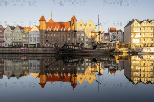 Waterfront promenade with reflection at sunrise in the Old Town, pirate ship, excursion boat,