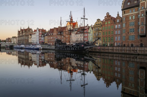 Waterfront promenade with reflection at sunrise in the Old Town, pirate ship, excursion boat,