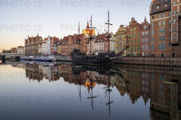 Waterfront promenade with reflection at sunrise in the Old Town, pirate ship, excursion boat,
