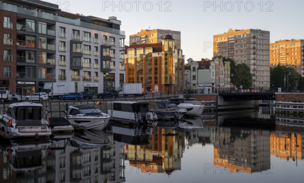 Waterfront promenade with reflection at sunrise in the old town, boat harbour, Motlawa River,