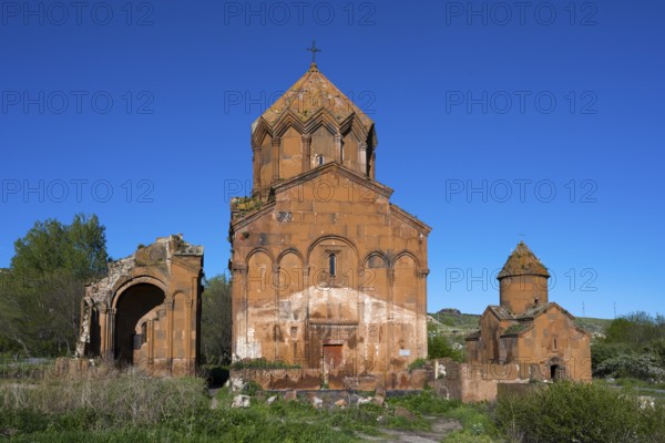 Historic brick church under a clear sky, surrounded by vegetation, cross-domed church, Marmashen